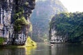 Scenic mountain lake with boats and high rocks covered by green forest